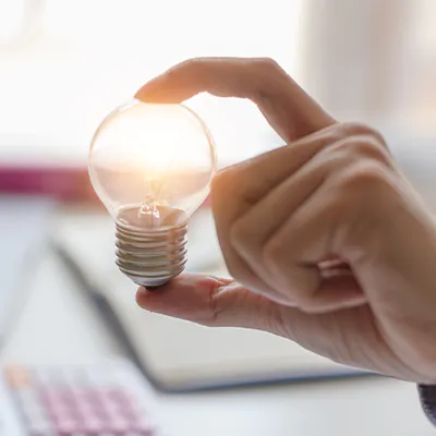 Hand hält LED-Glühbirne hoch